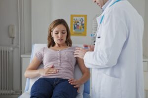 A woman talking to her gastroenterologist in New Jersey about her digestive discomfort in a medical setting.