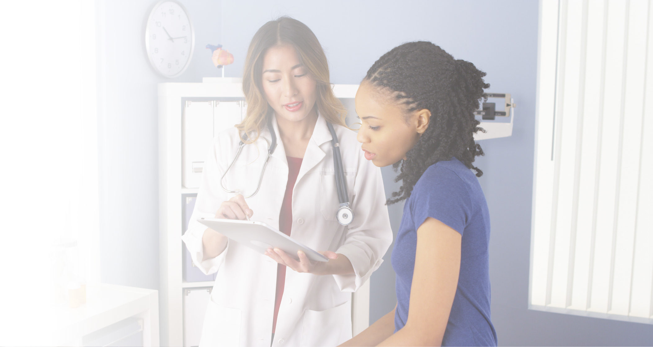 Female doctor and female healthcare provider viewing a tablet